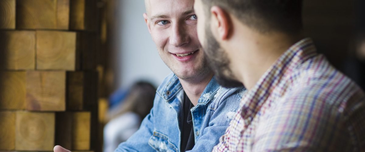 close-up-two-male-friends-sitting-together
